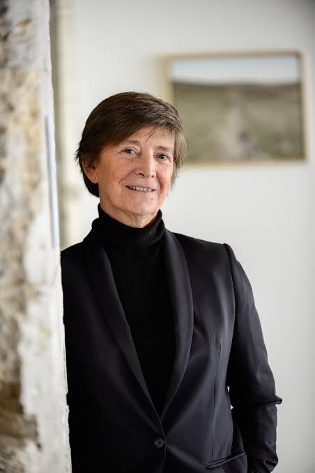 Nathalie Lamire-Fabre, fondatrice de la galerie, appuyée contre un pilier de pierre de la galerie.